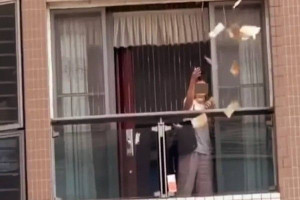 அடுக்குமாடி குடியிருப்பில் இருந்து பணத்தை கட்டுக்கட்டாக தூக்கி வீசிய பெண்