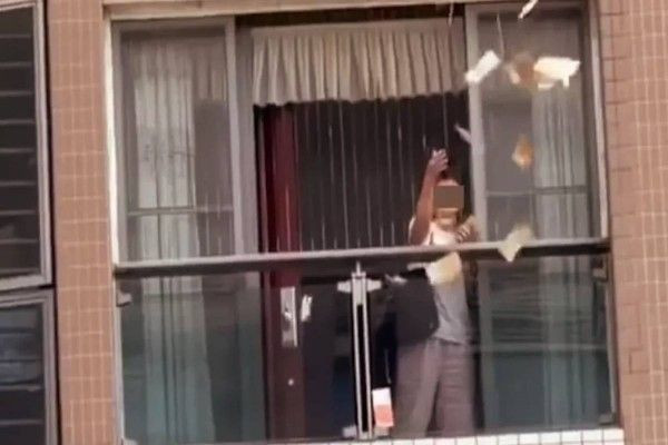 அடுக்குமாடி குடியிருப்பில் இருந்து பணத்தை கட்டுக்கட்டாக தூக்கி வீசிய பெண்